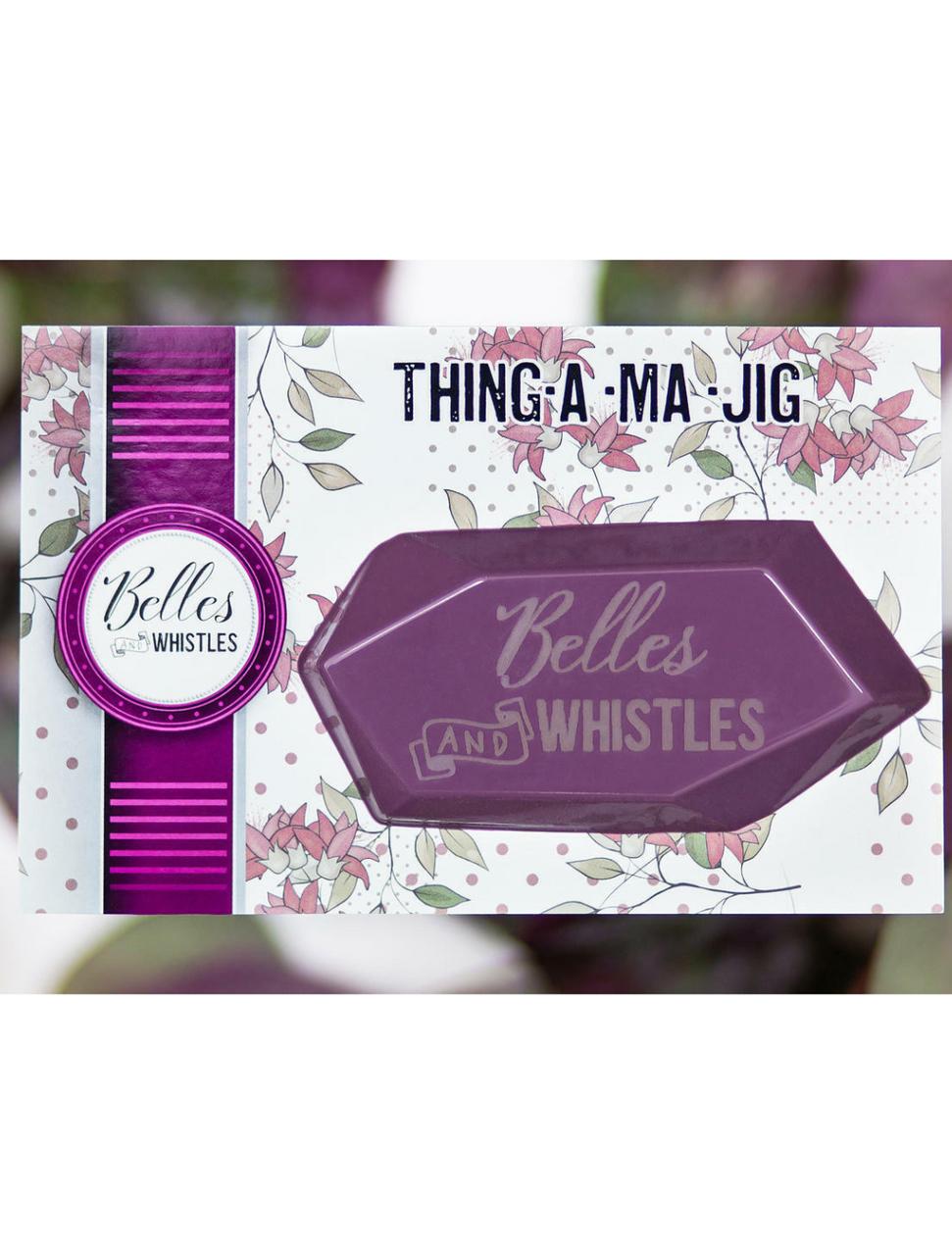 Belles and Whistles Thing-a-ma-jig - Thing-a-ma-jig in it's packaging with a purple, green and white blurred background