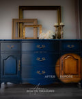 a moody dark blue chalk painted dresser.  blended with a lighter blue.  the bottom right corner of the dresser is a spotlight of the wood beneath the painted furniture.  On the top of the dresser is three empty picture frames, some flowers and two candle sticks.