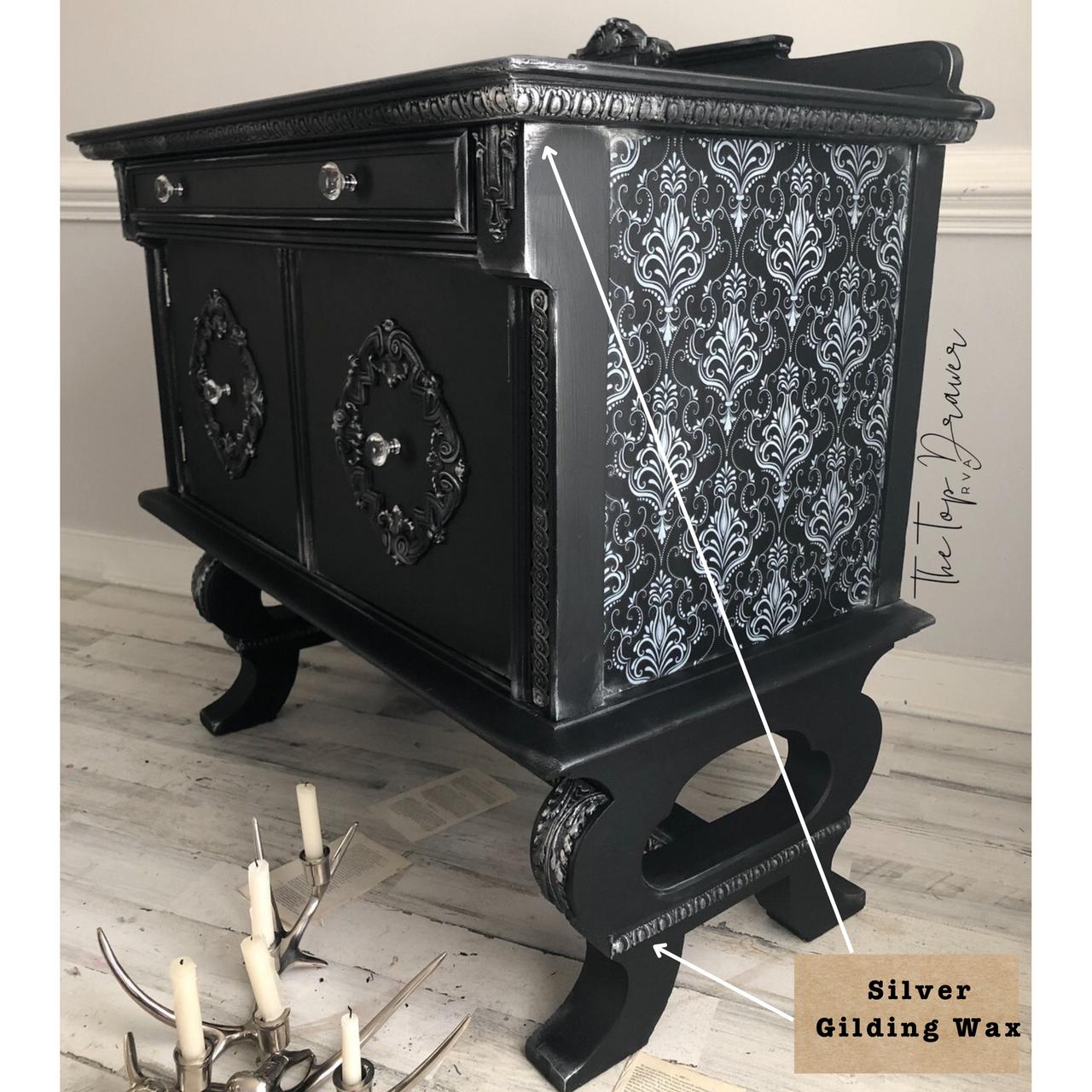 Dixie Belle Paint Gilding Wax on a Black Painted Dresser with the Lace Transfer applied to the side. A label with arrows pointing to the detail reads "Silver Gilding Wax."