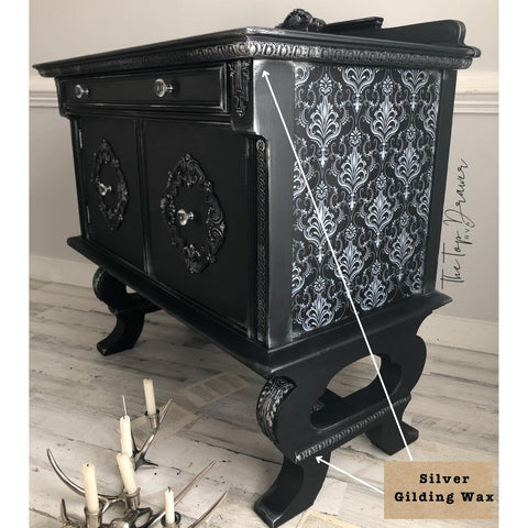 Dixie Belle Paint Gilding Wax on a Black Painted Dresser with the Lace Transfer applied to the side. A label with arrows pointing to the detail reads "Silver Gilding Wax."
