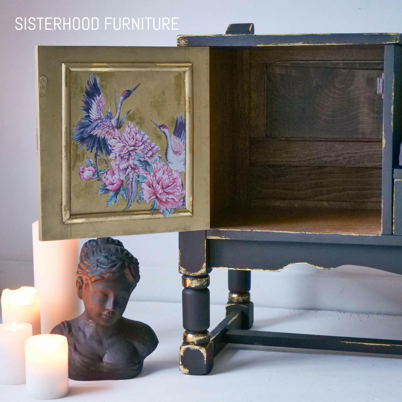 Black Distressed entertainment center with opened cabinet door. Inside of cabinet door is the Versailles Garden Transfer. Staged under the open cabinet door is 3 lit candles of different tiers with a bronze statue next to them.