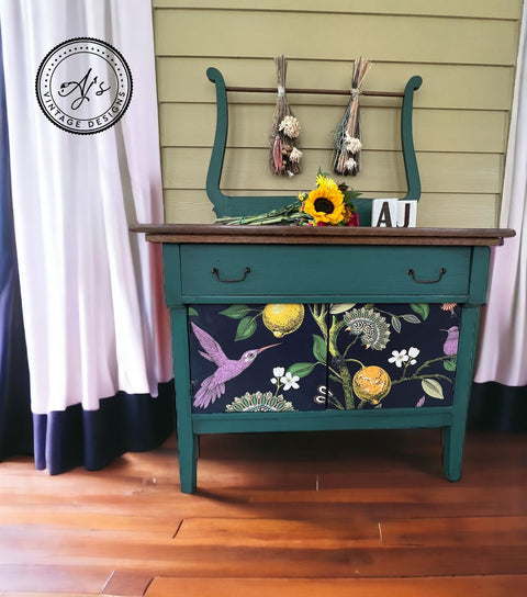 Blueish green painted dresser with black handles. The Vintage Botanical decoupage paper has been applied on the front of the cabinets.