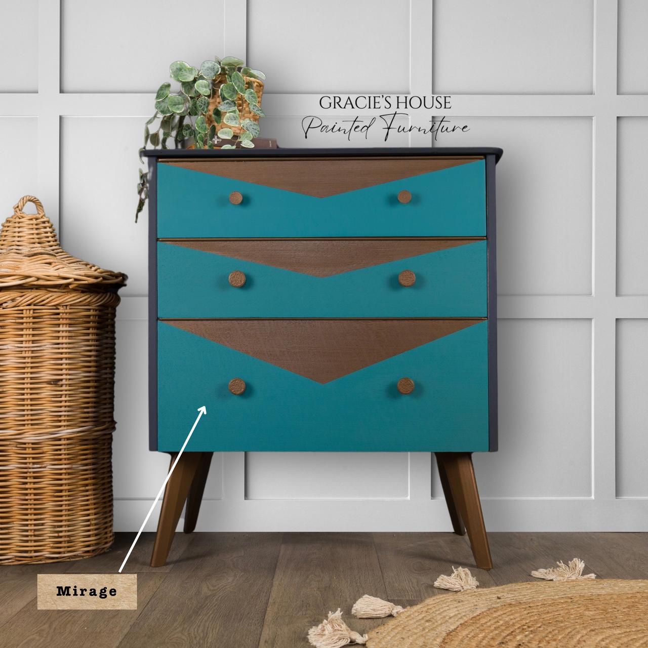 Mirage Silk All-In-One paint is perfect for painting kitchen cabinets, bathroom cabinets and painting furniture. A vintage-style dresser with teal and brown geometric patterns against a paneled wall, accented by a basket on the left and a plant on top. The text "GRACIE'S HOUSE Painted Furniture" and "Mirage Silk-All-in-One Mineral Paint" highlights elegance.
