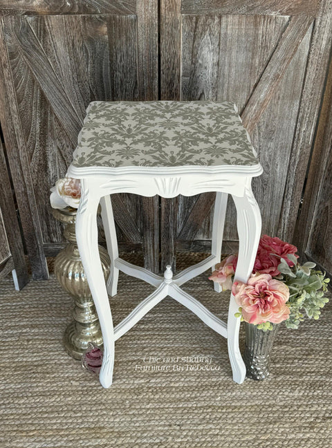 A white end table with Wedding Lace Transfer applied to the top of the table.
Staged with 2 vases of pink flowers and greenery on both sides of the table.