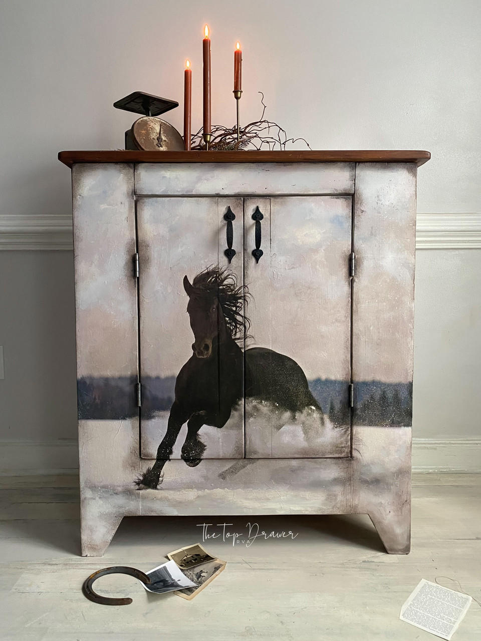 Vintage charm meets equestrian elegance: an exquisitely painted cabinet featuring the Winter Gallop A1 Rice Decoupage Paper showcasing a majestic horse, set against a serene backdrop, inviting a touch of the wild into a tranquil home setting.