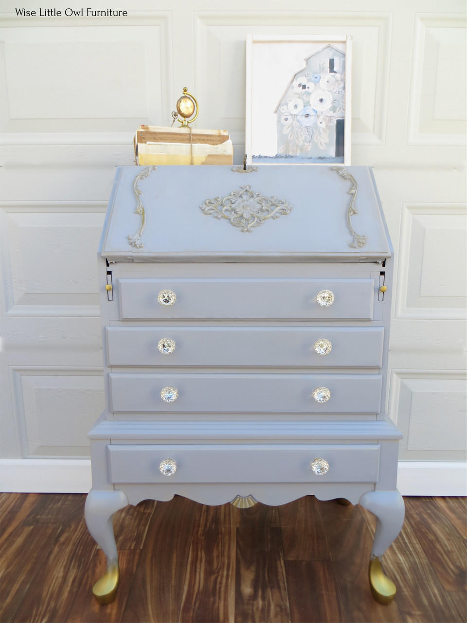 WoodUBend Applique #1245.26 (set of 2) is the perfect mouldable embellishment for any project! Applique #1245.26 set on top of light blue chalk painted dresser with angled opening top. The dresser is embellished with other Wood U Bend designs such as keyhole and has gold feet.