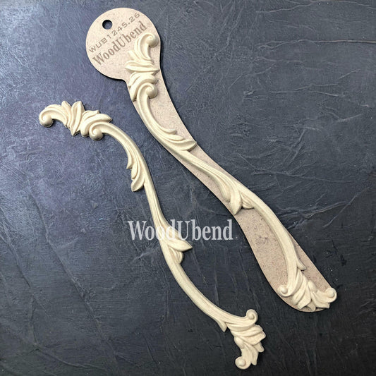 WoodUBend Applique #1245.26 (set of 2) is the perfect mouldable embellishment for any project! Applique #1245.26 beside and on packaging against black background. Shows 2 molds.