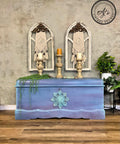 WoodUBend Applique #1323.26 (Set of 2) is the perfect mouldable embellishment for any project! Applique #1323.26 (Set of 2) mounted on front of turquoise  chalk mineral painted chest. The chest is staged with candles and vegetation.