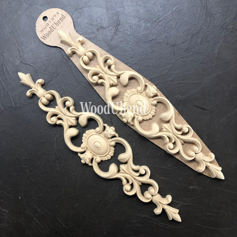 WoodUBend Applique #1374 (Set of 2) is the perfect mouldable embellishment for any project! Image shows two WoodUBend Applique #1374 with its packaging against a black background.