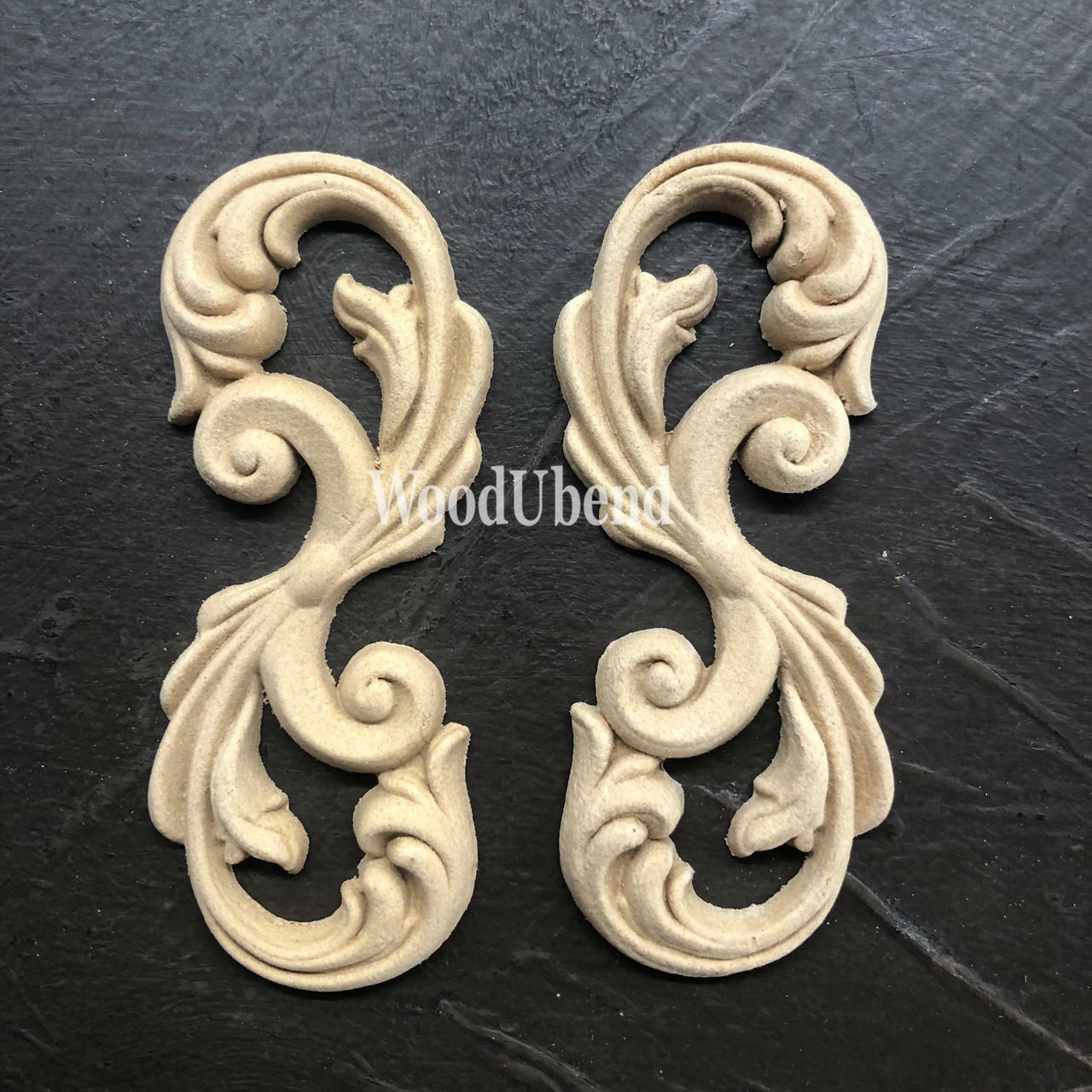 WoodUBend Applique #2150 (Set of 2) is the perfect mouldable embellishment for any project!
Applique #2150 (Set of 2) is seen side by side staged on top of a black crinkled background.