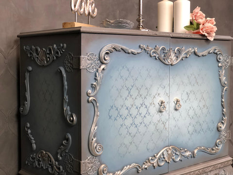 Applique #2152 Set of 2 is the perfect mouldable embellishment for any project!
A bar cabinet with woodwork around the front of the doors as well as the side of the cabinet you can see Applique #2152 Set of 2 on the top and bottom center of the cabinet as well as the side panel on the top and bottom.