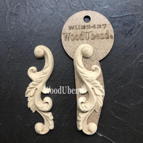 WoodUBend Applique #2437 (set of 2) is the perfect mouldable embellishment for any project! Image shows two Applique #2437 (set of 2) with packaging against a black background.