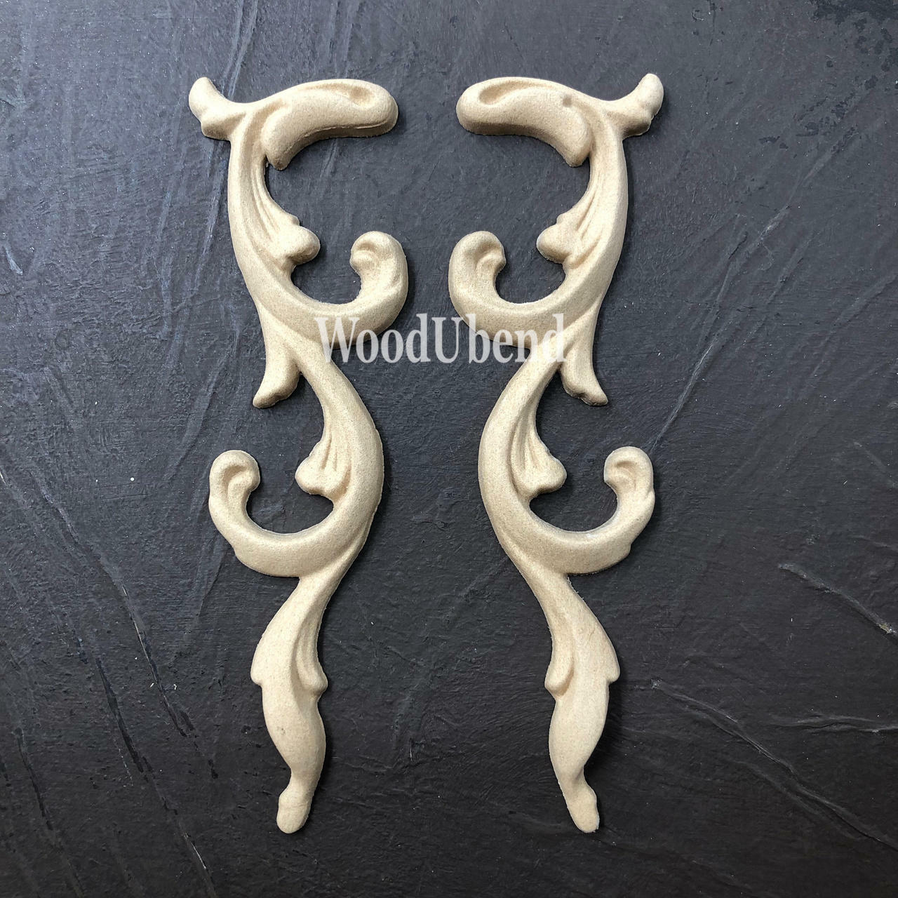 WoodUBend Applique #366-7 (set of 2) is the perfect mouldable embellishment for any project!
The Applique #366-7 (set of 2) set side by side inverted on top of a black crinkled background.