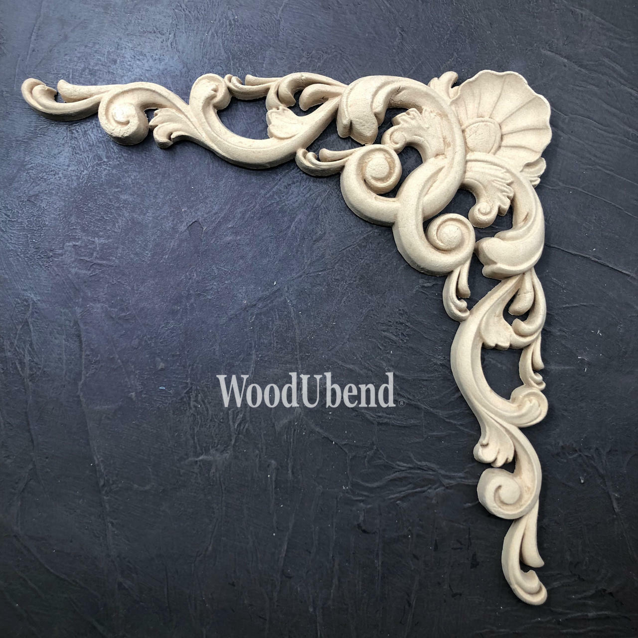 WoodUBend Applique #6069 (Set of 2) is the perfect mouldable embellishment for any project!
This shows one piece of the two pack of the WoodUBend package.  It is the Applique that looks like it could be used as a corner on a piece of furniture.  Its wavy and frilly with a sea shell on the top part of the curve.