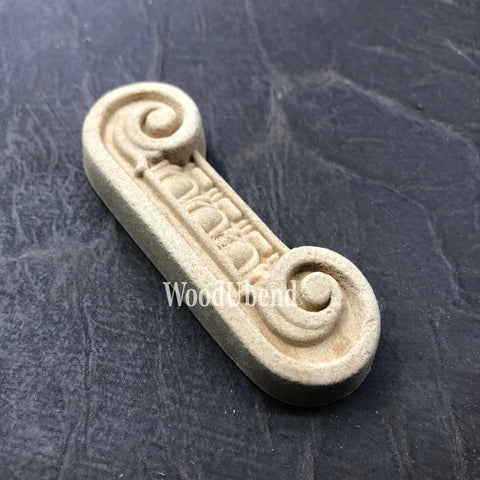 WoodUBend Applique #6081 (Set of 2) is the perfect mouldable embellishment for any project!
One of the Applique #6081 (Set of 2) is seen flat and facing to the right. Staged on a black crinkled background.