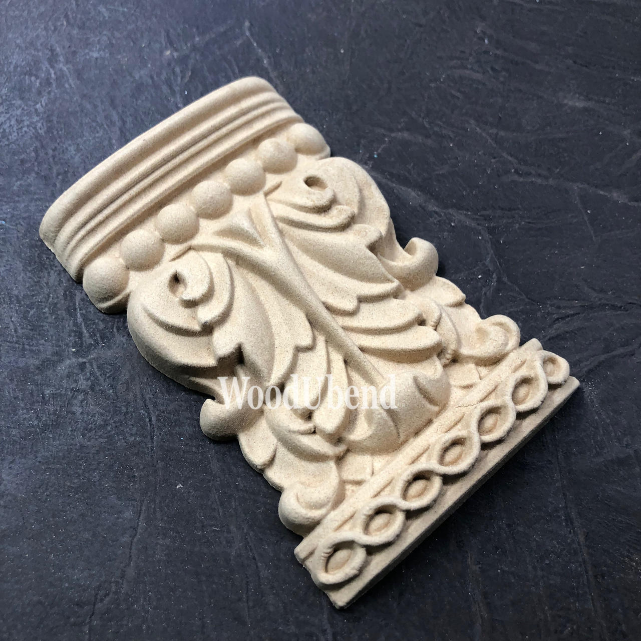 WoodUBend Applique #6088 (Set of 2) is the perfect mouldable embellishment for any project!
One Applique #6088 (Set of 2) staged diagonally on a black crinkled background.