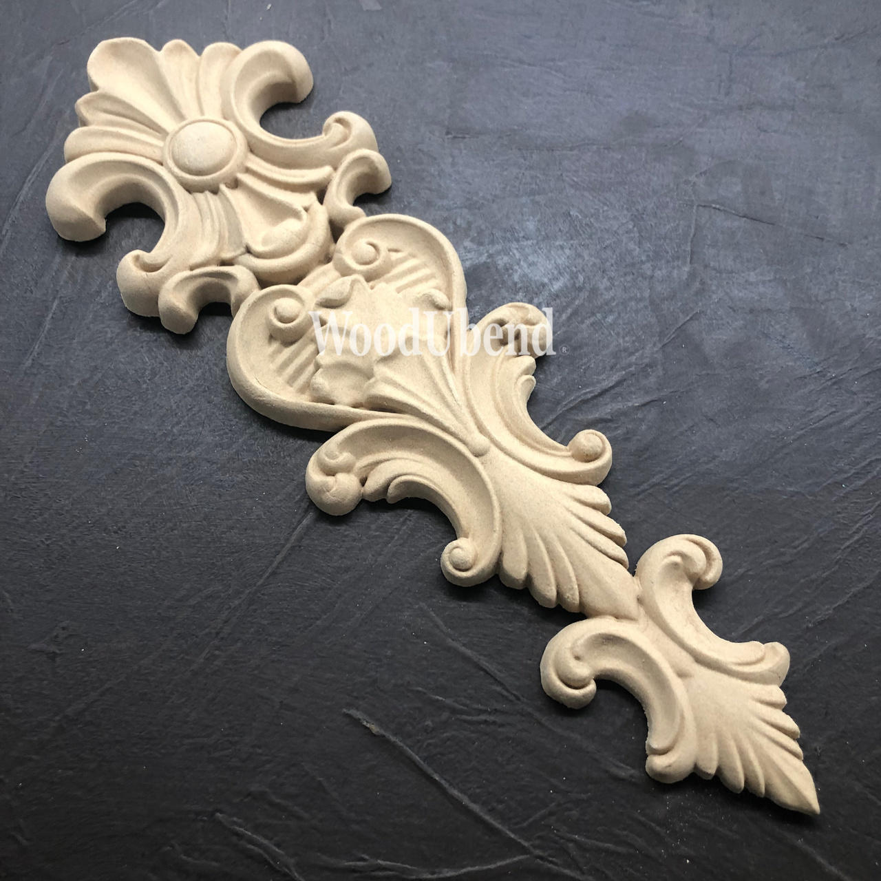 WoodUBend Applique #X1002 is the perfect moldable embellishment for any project!
The Applique #X1002 is seen displayed flat and staged on a black crinkled background.