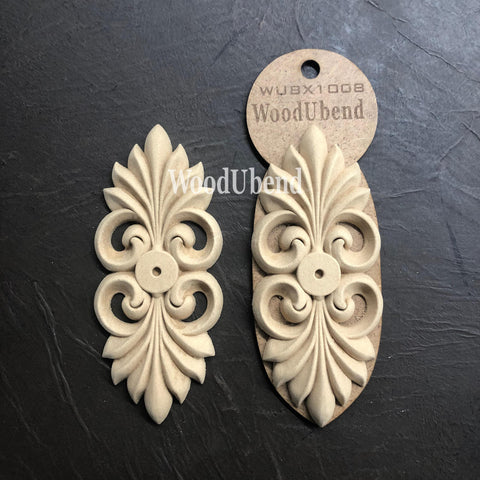 WoodUBend Applique #X1008 is the perfect mouldable embellishment for any project!
The Applique #X1008 is seen in its packaging and another side by side without packaging. Staged flat on top of a black crinkled background.