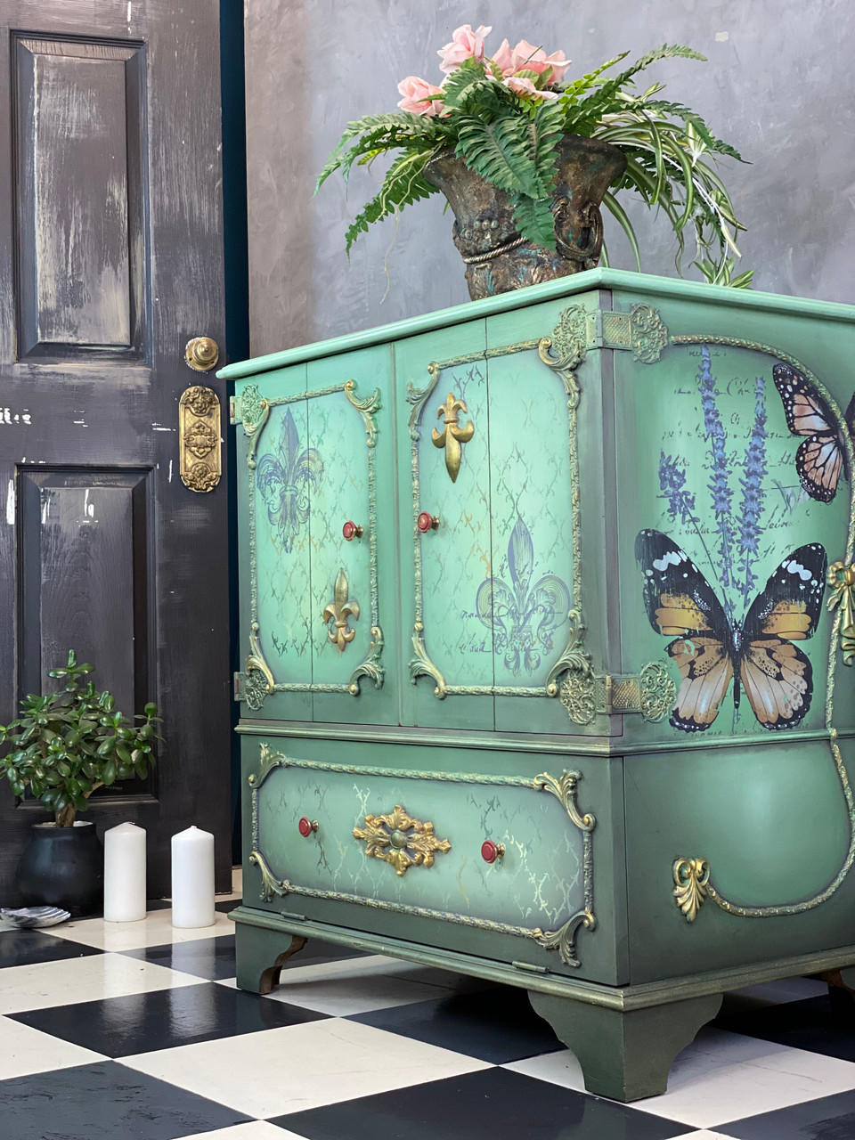 WoodUBend Applique #X1009 is the perfect mouldable embellishment for any project!
A furniture piece with wood border around the front cabinets and drawers as well as the side panel. You can see Applique #X1009 are the end of the woodwork. Staged with greenery and white candles.