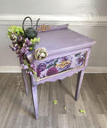 WoodUBend Fleur-de-lis Applique #2092 (set of 2) 
Here is a lavender table with flower decoupage on the front and a Fleur-de-lis applique in the center of the front and back lift.  It is staged with flowers and a watering pot.