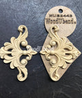 WoodUBend Fleur-de-lis Applique #2443 (set of 2) is the perfect mouldable embellishment for any project!
An image of the Fleur-de-lis Applique #2443 Set of 2 , one of them are in its packaging while the other is out facing each other. Staged on a black crinkled background.