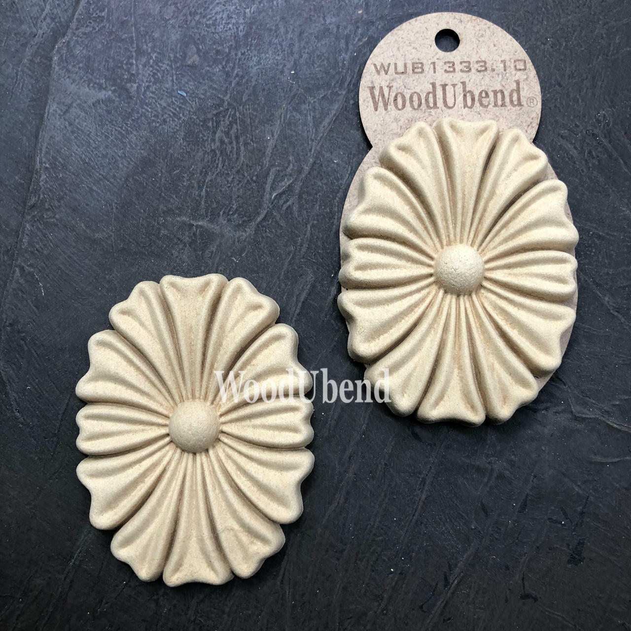 WoodUBend Floral Applique #1333.1 (Set of 2) is the perfect mouldable embellishment for any project!
Image shows the full set of Floral Applique #1333.1 staged diagonally besides each other, one in its packaging the other one out, on top of a black background.