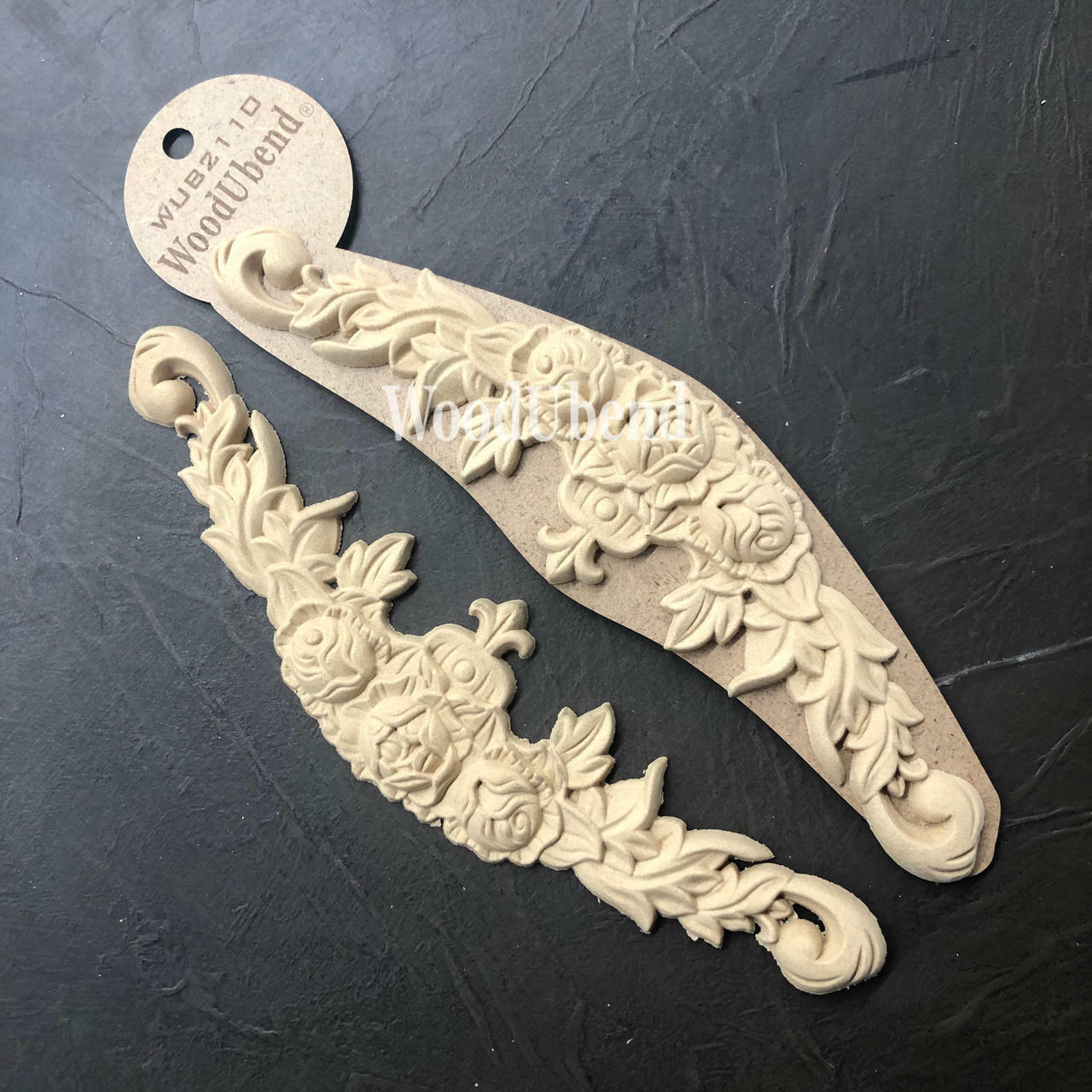 WoodUBend Floral Applique #2110 (set of 2) 
The Floral Applique #2110 staged side by side, with one in its packaging the other without. Staged on a black background.