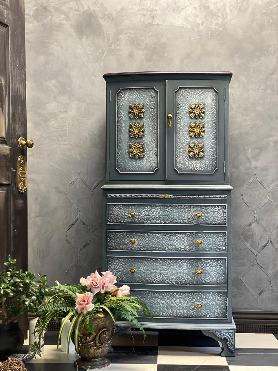 WoodUBend Floral Applique #2427 (set of 2) is the perfect mouldable embellishment for any project!
A chest of drawer with a cabinet at the top, on the cabinet doors you can see 3 Floral Applique #2427 on both sides going down in the middle. Staged with a bronze pot with greenery and flowers in front of the piece.