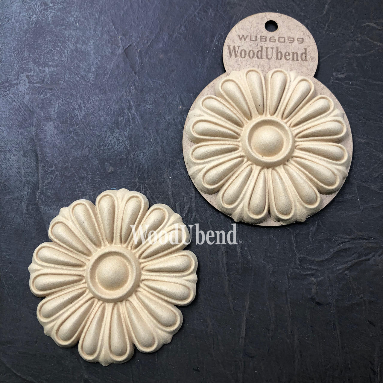 WoodUBend Floral Applique #6099 (Set of 2) is the perfect mouldable embellishment for any project!
The Floral Applique #6099 (Set of 2) one being in the packaging and the other without. Staged on a a black crinkled background.