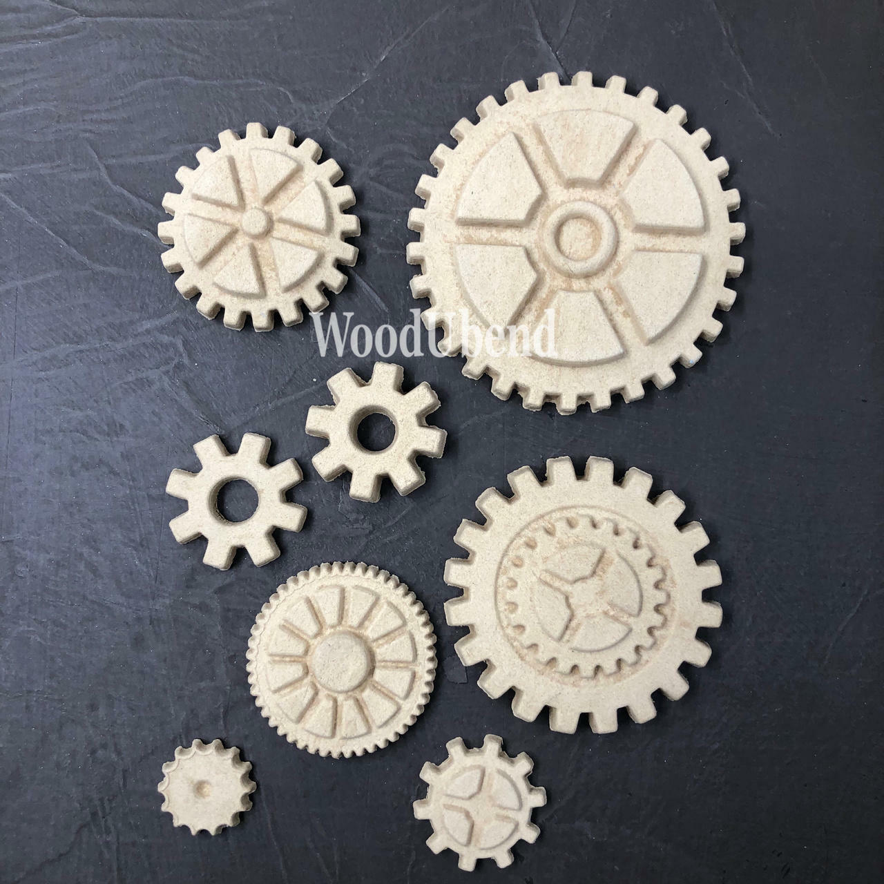 WoodUBend Gear Collection Appliques #56 is the perfect mouldable embellishment for any project!
The Gear Collection Appliques #56 without its packaging staged on a black crinkled background.