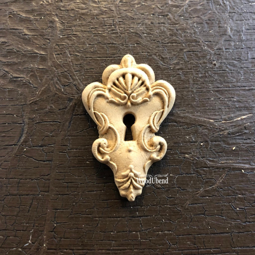 WoodUBend Keyhole #990 (Set of 5) 
This WoodUBend looks like a sugar cookie.  There's a keyhole, the top of the applique is wider than the bottom.  The bottom comes to a point.  There are a lot frills around the keyhole.