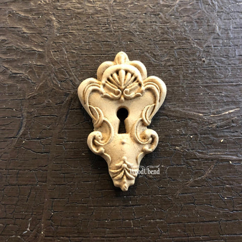 WoodUBend Keyhole #990 (Set of 5) 
This WoodUBend looks like a sugar cookie.  There's a keyhole, the top of the applique is wider than the bottom.  The bottom comes to a point.  There are a lot frills around the keyhole.