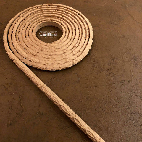 WoodUBend Trim #TR37 is the perfect mouldable embellishment for any project!  A roll of WoodUBend Trim #TR37 lying on a table, unraveling at 1 end.