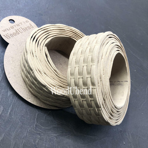 WoodUBend Trim #TR716 (Set of 2) is the perfect mouldable embellishment for any project!  Two rolls of WoodUbend sitting on top of a brown piece of paper with WoodUbend WUBTR716 printed at the top; all are sitting on a black table.