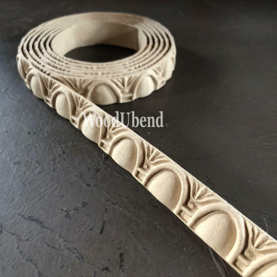 WoodUBend Trim #TR718 (Set of 2) is the perfect mouldable embellishment for any project!  A roll of WoodUbend sitting on a brown table, unrolling at one end.