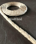 WoodUBend Trim #TR722 (Set of 2) is the perfect mouldable embellishment for any project!  A roll of WoodUbend sitting on a brown table, unrolling at one end.