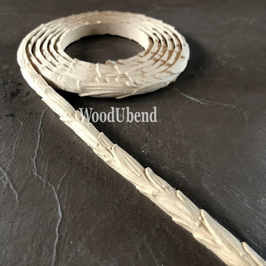 WoodUBend Trim #TR722 (Set of 2) is the perfect mouldable embellishment for any project!  A roll of WoodUbend sitting on a brown table, unrolling at one end.