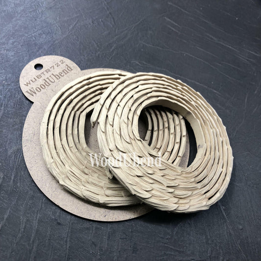 WoodUBend Trim #TR722 (Set of 2) is the perfect mouldable embellishment for any project!  Two rolls of WoodUbend sitting on top of a brown round cardboard cutout with WoodUbend WUBTR722 printed at the top; all sitting on a black table.