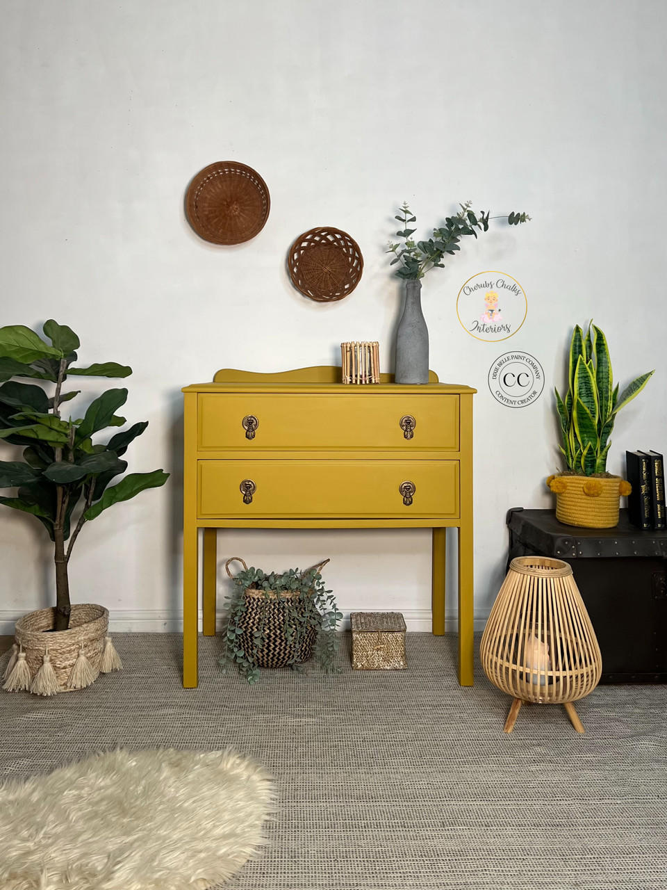 Yellow painted two drawer dresser transformation with bronze pulls. Staged with a gray textured vase containing faux greenery and a bamboo candle holder on top.