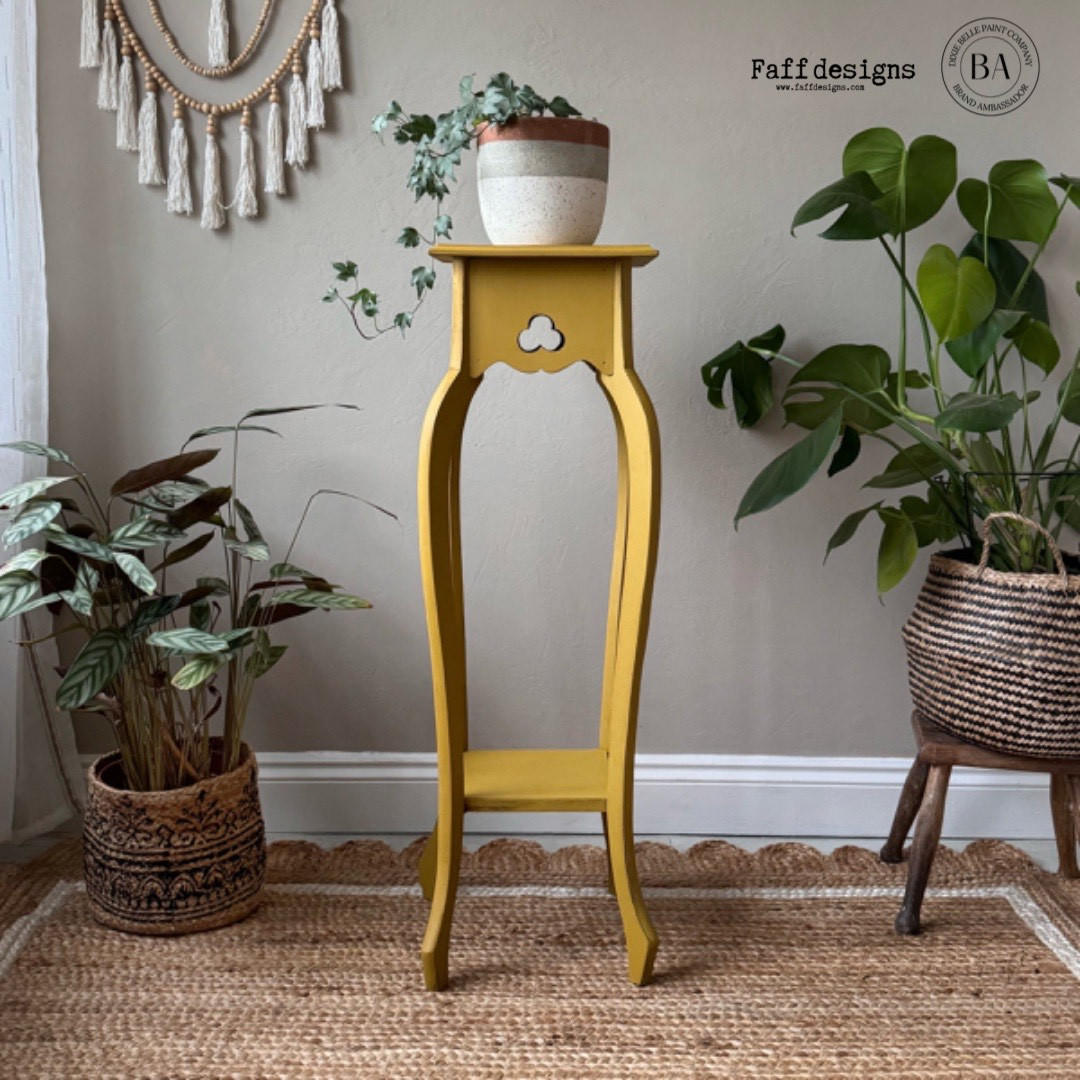Yellow painted plant stand table makeover with a white, silver, and bronze pot containing a faux Pothos on top.